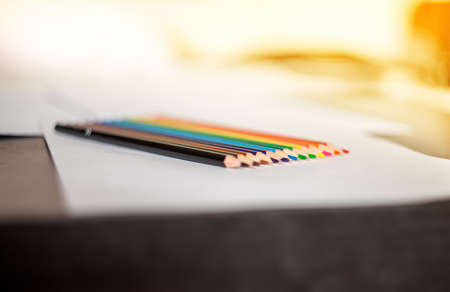 colored pencils are prepared for drawing on white sheets of paper in the order of the colors of the...