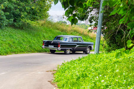 Black car "Chaika". GAZ-13 "Chaika" produced by the USSR in the 1960s. The car is on an asphalt road in the forest. Moscow, Russia, July 2018のeditorial素材