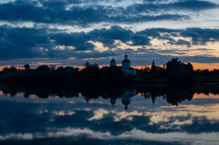 Beautiful reflection of the Church and the evening colorful sky in the calm water of the lake on a warm summer eveningの写真素材