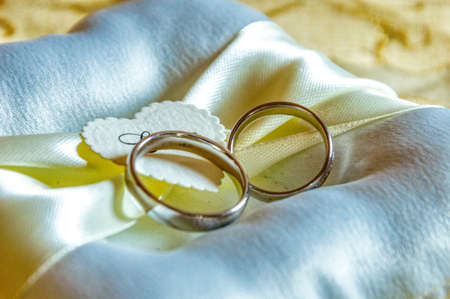 Wedding rings in white gold on a pillow with the inscription loveの写真素材