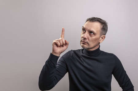 A white middle aged man of European appearance with gray in his hair and a slightly unshaven face in...