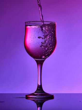Different glass goblets on a and purple background. Beautiful still lifeの写真素材