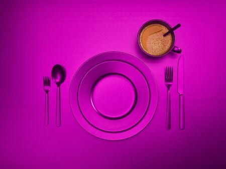Cup of coffee with purple plates, fork, knife and spoon, top view. Ceramic dishes with a set of cutlery. Empty purple dishes for breakfast or dinner in a restaurant. Copyspace for your individual text.の写真素材