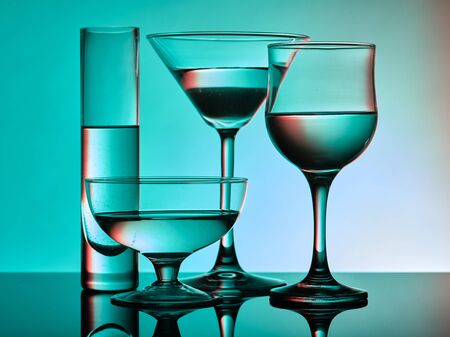 Different glass goblets on a turquoise background. Beautiful still lifeの写真素材