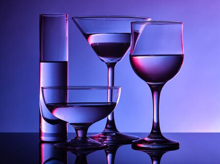 Different glass goblets on a and purple background. Beautiful still lifeの写真素材