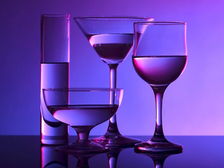 Different glass goblets on a and purple background. Beautiful still lifeの写真素材
