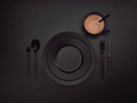 Cup of coffee with black plates, a fork, a knife and a spoon, top view. Ceramic dishes with a set of cutlery. Empty black dishes for breakfast or dinner in a restaurant. Copyspace for your individual text.