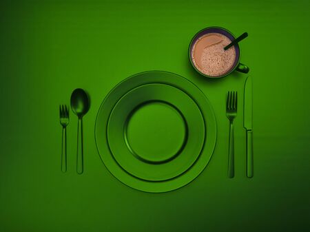 Cup of coffee with green plates, fork, knife and spoon, top view. Ceramic dishes with a set of cutlery. Empty tableware for breakfast or dinner in a restaurant. Copyspace for your individual textの写真素材