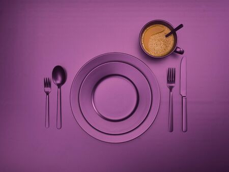 Cup of coffee with pink plates, fork, knife and spoon, top view. Ceramic dishes with a set of cutlery. Empty pink dishes for breakfast or dinner in a restaurant. Copyspace for your individual text.の写真素材