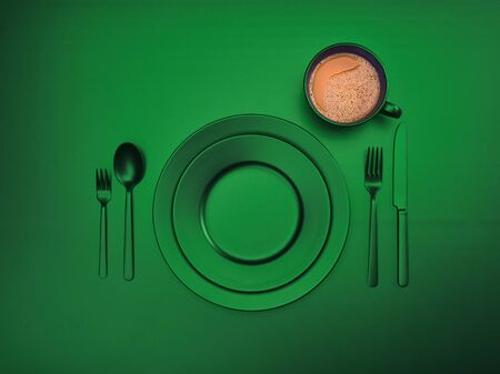 Cup of coffee with green plates, fork, knife and spoon, top view. Ceramic dishes with a set of cutlery. Empty tableware for breakfast or dinner in a restaurant. Copyspace for your individual textの写真素材