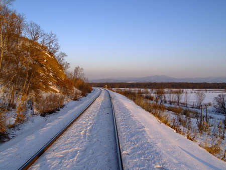 Winter landscape with railway rails at a mountain slope     の写真素材