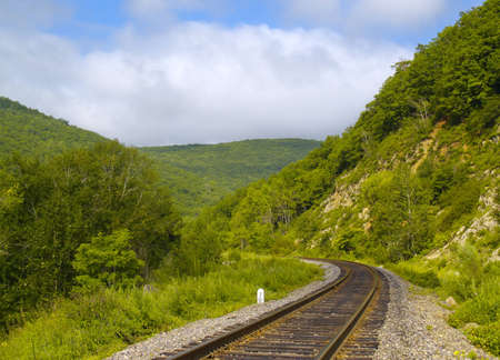 Year landscape with railway line, hills and cloudy sky 