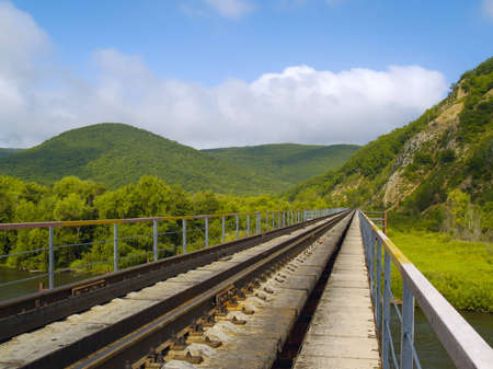 Year landscape with railway line, hills and cloudy sky    の写真素材