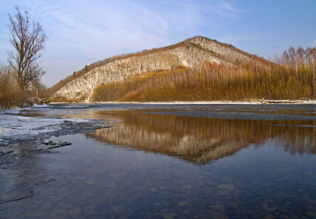 Winter landscape with small river at a mountain slopeの写真素材