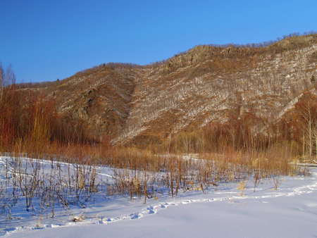 Winter sunny day on glade at a mountain slope 