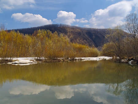 Spring landscape with last snow on river bankの写真素材