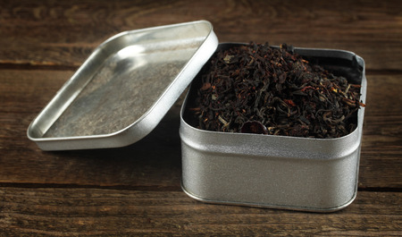 Open a tin box of tea on a rough wooden tableの写真素材