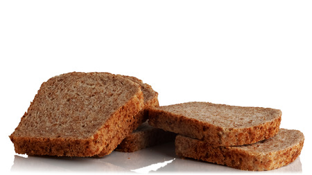 cut into pieces a loaf of bread from sprouted grains on a white background