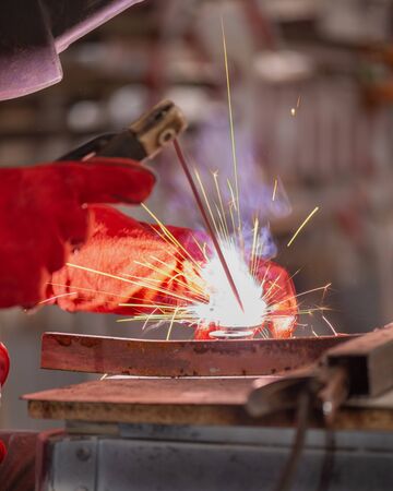 worker in a protective suit performing welding work, close -up