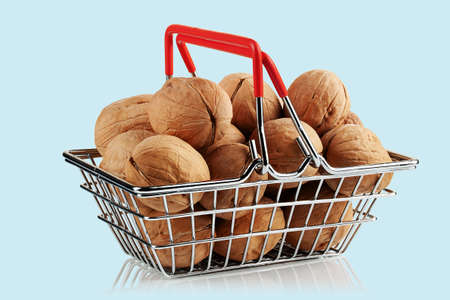 walnuts in a toy metal basket on a light background