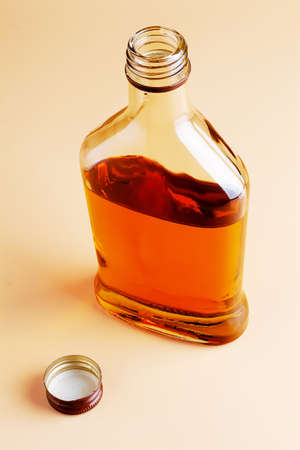 A small flat glass brandy bottle on a uniform backgroundの写真素材