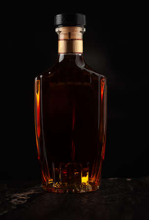 A full bottle of brandy on a dark backgroundの写真素材