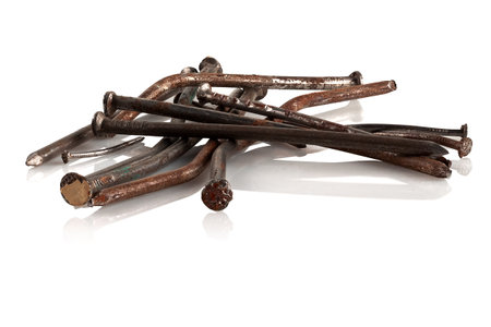 Old, rusty, bent nails on a white background.の写真素材