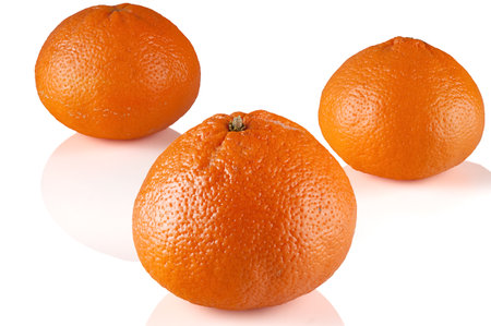 three large ripe tangerines close-up on a white backgroundの写真素材