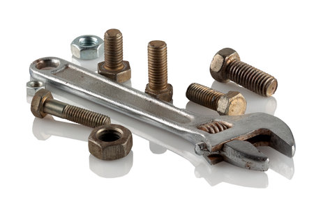 Steel wrench and bolts, nuts on a reflective white backgroundの写真素材