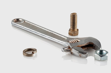 Steel wrench , bolt and nut on a reflective light backgroundの写真素材