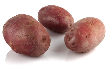 potatoes with red peel on a white reflective backgroundの写真素材
