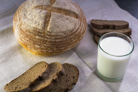 Background food ingredients on the tablecloth. Homemade bread and milk.の写真素材