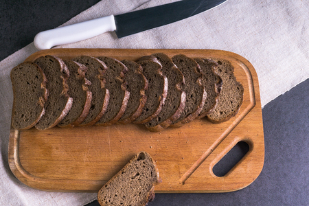 Background food ingredients on the tablecloth and the kitchen Board. Fresh tomatoes and homemade bread. Knife.の写真素材
