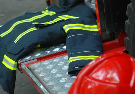 Fireman's jacket and helmet, on the back of a fire engine, equipmentの写真素材