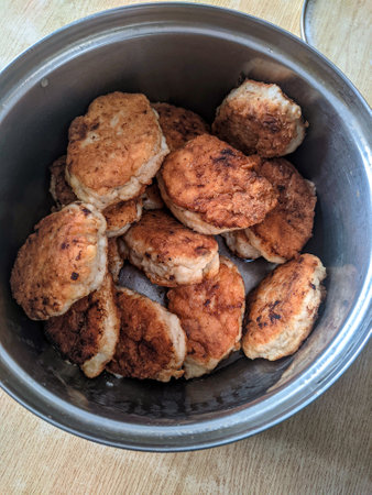 photo image of a cooked chicken meat cutlets in the pan on a table