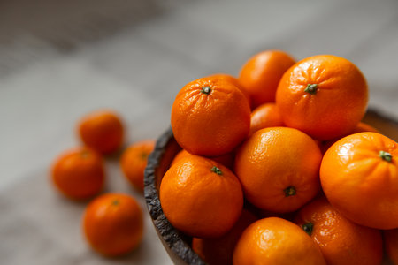Basket with tangerine or orange fruit on a gray plaid background.の写真素材