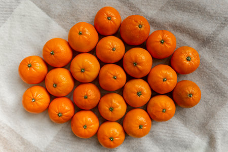 Basket with tangerine or orange fruit on a gray plaid background.の写真素材