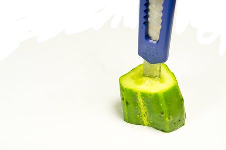 wounded cucumber with a knife in the backの写真素材