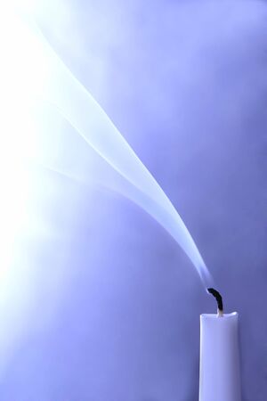 extinguished candle on blue backgroundの写真素材