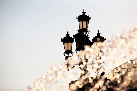 the fountain in the sunlight on the background of street lightsの写真素材