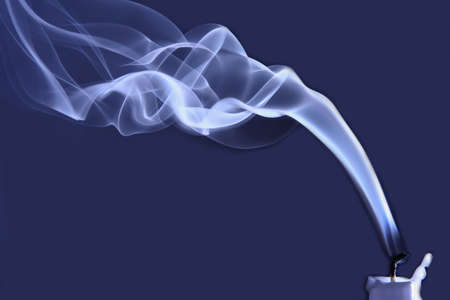 one extinguished candle in the smokeの写真素材