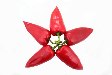 five bright red sweet peppers on a white backgroundの写真素材