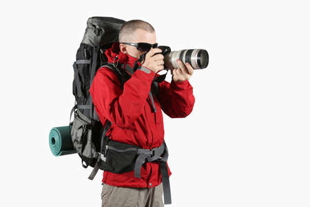 tourist in a red jacket with a gray backpack taking picturesの写真素材