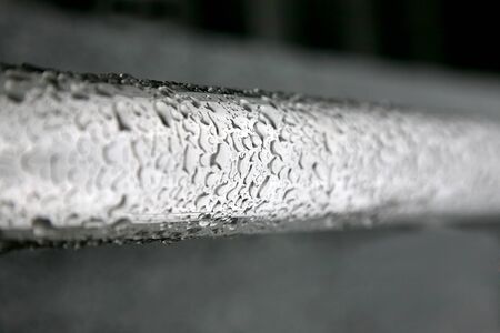 the water drops on a metal pipe after the rainの写真素材