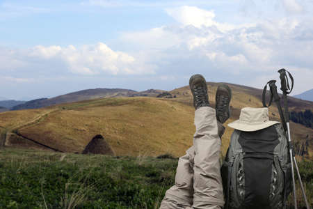 the tourist crossed her legs up near a backpack in natureの写真素材