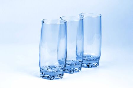 the three blue transparent glass with a light blue backgroundの写真素材