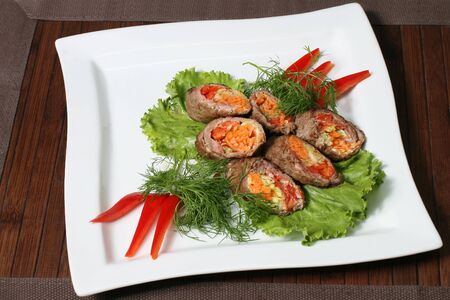 the pieces of fried meat stuffed in green peppers, carrots and onionsの写真素材