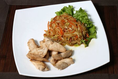 the fried pieces of chicken with a salad of cabbage and carrotsの写真素材