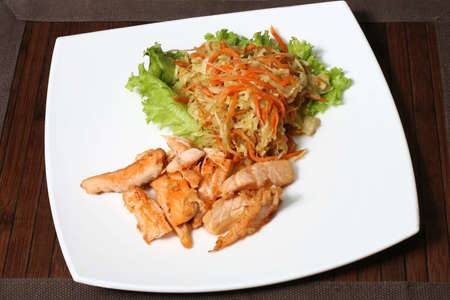 the fried fish with a salad of cabbage and carrotsの写真素材