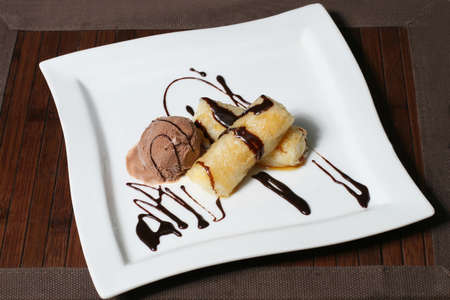the dessert of ice cream and bananas with chocolate glazeの写真素材